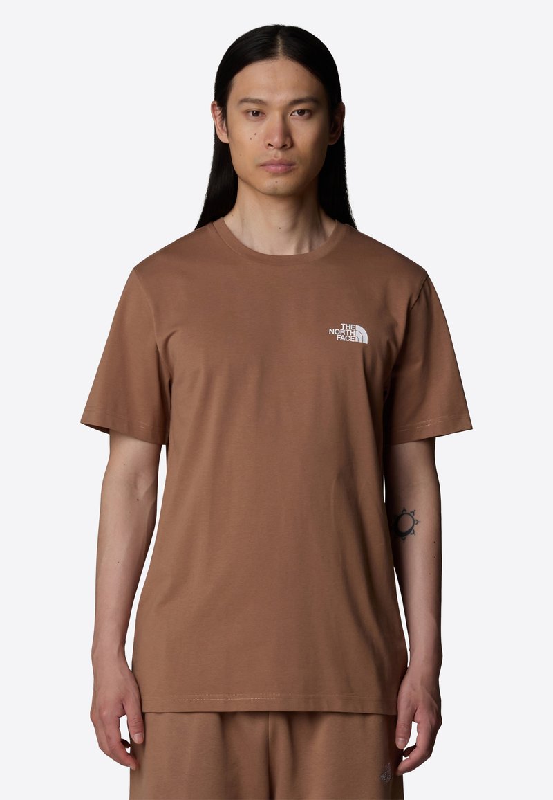 Bruine katoenen t-shirt met korte mouwen en ronde hals. Voorzien van een klein wit logo op de linkerborst en een ontspannen pasvorm.