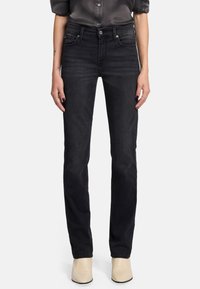 Svarta denimjeans med rak passform, femfickorsdesign, knäppning och en subtil textur, tillsammans med beige ankelstövlar.