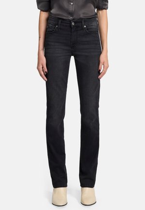 Schwarze denims mit geradem Schnitt, Fünf-Taschen-Design, Knopfverschluss und einer dezenten Textur, kombiniert mit beigen Stiefeletten.
