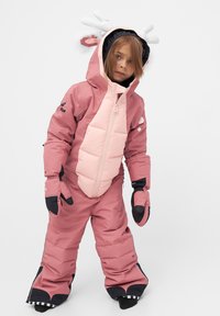 Rosa snösuit med vadderad framsida, matchande handskar och en huva med vita horn. Inkluderar svarta detaljer och dragkedjestängning för att hålla värmen.
