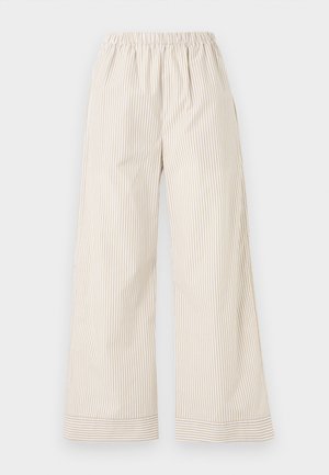Pantalon à jambes larges avec des rayures verticales beige et blanches, taille élastique et poignets aux chevilles avec des rayures horizontales.
