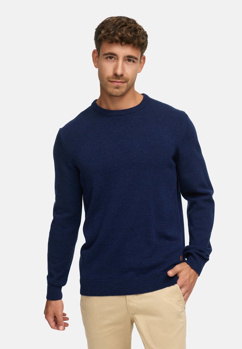 Suéter de punto azul marino con mangas largas y cuello redondo. Puños y dobladillo acanalados con un pequeño detalle de logo en la cintura.