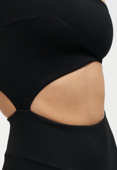 Μαύρο αμάνικο φόρεμα με λεπτομέρεια κοψίματος στο πλάι που δείχνει γυμνό δέρμα στη μέση και στην πλάτη, εφαρμοστή γραμμή.