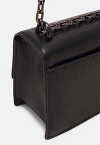 Borsa in pelle nera di forma rettangolare, con superficie testurizzata, tracolla a catena e bordi puliti. Accenti metallici notevoli visibili.