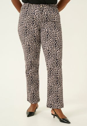 Pantaloni con stampa leopardata in beige e marrone scuro, caratterizzati da un design a gamba dritta e una texture liscia, abbinati a tacchi a punta neri.