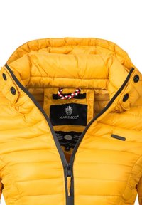 Yellow quilted puffer jacket with a gray zipper and button accents. Interior features a black label with logo and drawstring hood.