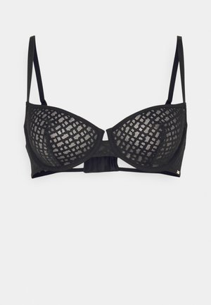 Black lace underwired bra featuring geometric pattern, adjustable straps, and a solid band at the back. Textured mesh fabric.