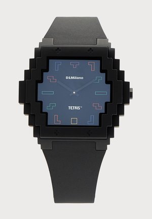 Čierne hodinky s pixelovaným štvorcovým puzdrom, modrým ciferníkom zobrazujúcim farebné tvary Tetrisu a textom "D1Milano" a "Tetris".