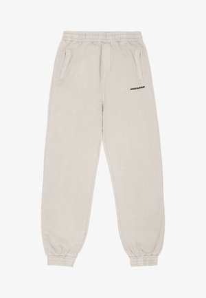 Vaaleanbeiget joustavat housut, jotka on valmistettu pehmeästä materiaalista. Niissä on joustava vyö, kaksi sivutaskua ja pieni musta logo.