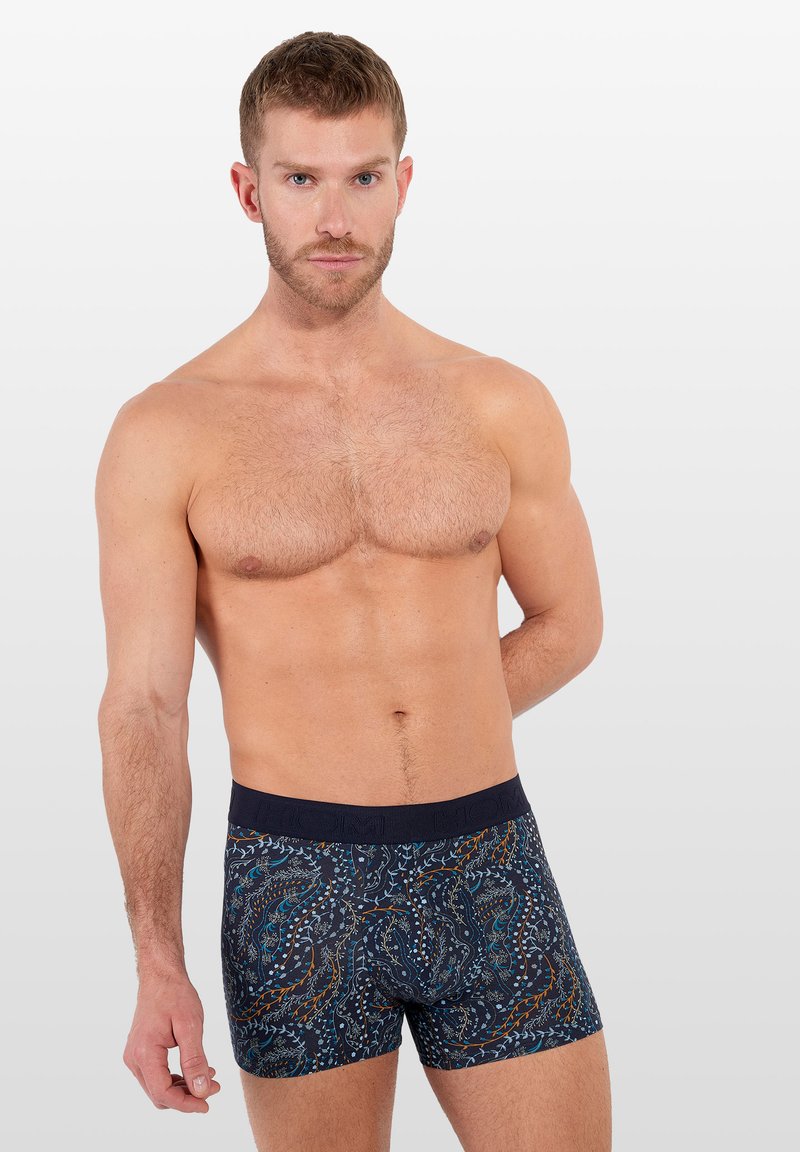 Marineblauwe boxershorts met een bloemenpatroon in blauw en oranje. Gemaakt van zachte stof met een comfortabele elastische tailleband.