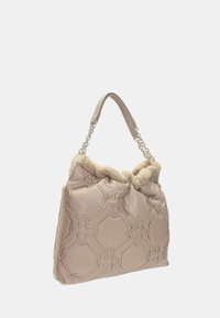Sac fourre-tout beige avec un design matelassé, présentant une bordure moelleuse de couleur crème et une sangle d'épaule agrémentée de chaînes.