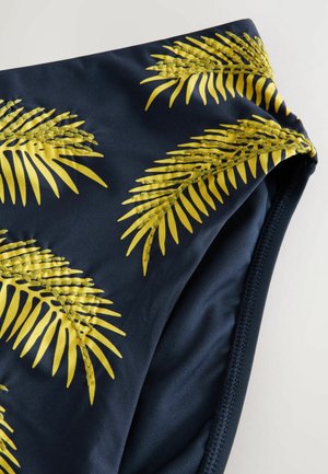 Navy blå bikini bund med gult palmebladtryk. Fremstillet af glat stof med elastisk talje. Sømme detaljer langs kanterne.