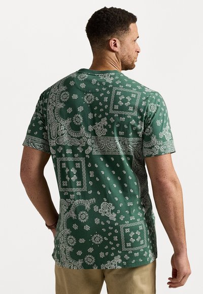 Grønn kortermet skjorte med hvite paisley- og blomsterdesign. Har en avslappet passform og rund kant, laget av lett stoff.