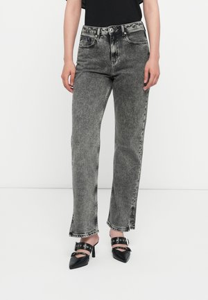 Gray high-waisted jeans with a faded finish, straight leg, and contrasting stitching. Paired with black pointed mules featuring cutout accents.