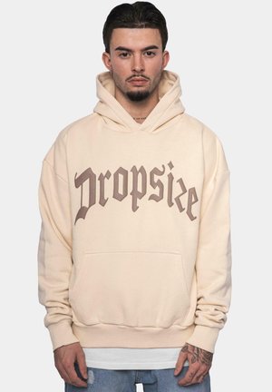 Beige hettegenser med frontlomme og snor i hetten. Har fet brun tekst "Dropsize" i gotisk skrifttype. Myk stoff med ribbede mansjetter.