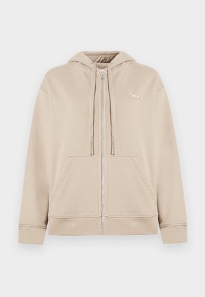 Beige Zip-Hoodie aus weichem Stoff, mit Kängurutasche, verstellbarem Kapuzenzug und einem kleinen Logoakzent auf der Brust.