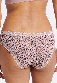 Gennemsigtig lyserød undertøj med blonder og flerfarvet prikmønster i mørkere nuancer. Glat tekstur med lav talje.