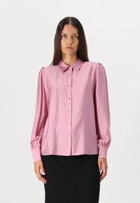 Camisa rosa com botões, colarinho, mangas longas e ombros bufantes; feita de um tecido brilhante com pequenos botões e uma textura suave.
