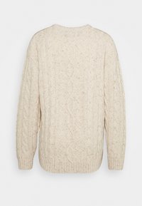 Kraftig krämfärgad kabelstickad tröja med ribbad nederkant och ärmslut, som har intrikata texturerade mönster genom hela tyget.