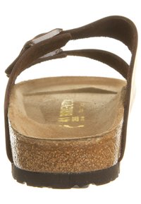 Brun lædersandal med to justerbare remme, en anatomisk korkfodseng og en struktureret gummisål. Flad design med minimal hardware.