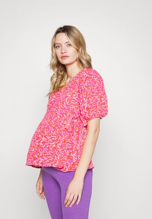 Top rosa floral de mangas curtas com um design franzido, apresentando um decote em V e um laço lateral, combinado com leggings roxas justas.