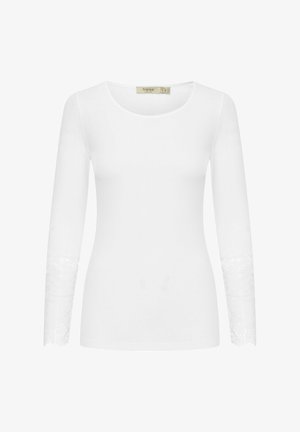 Bela dolgimi rokavi majica iz mehke tkanine, z čipkastimi detajli na manšetah in okroglo ovratnico za prilegajoč silhueto.