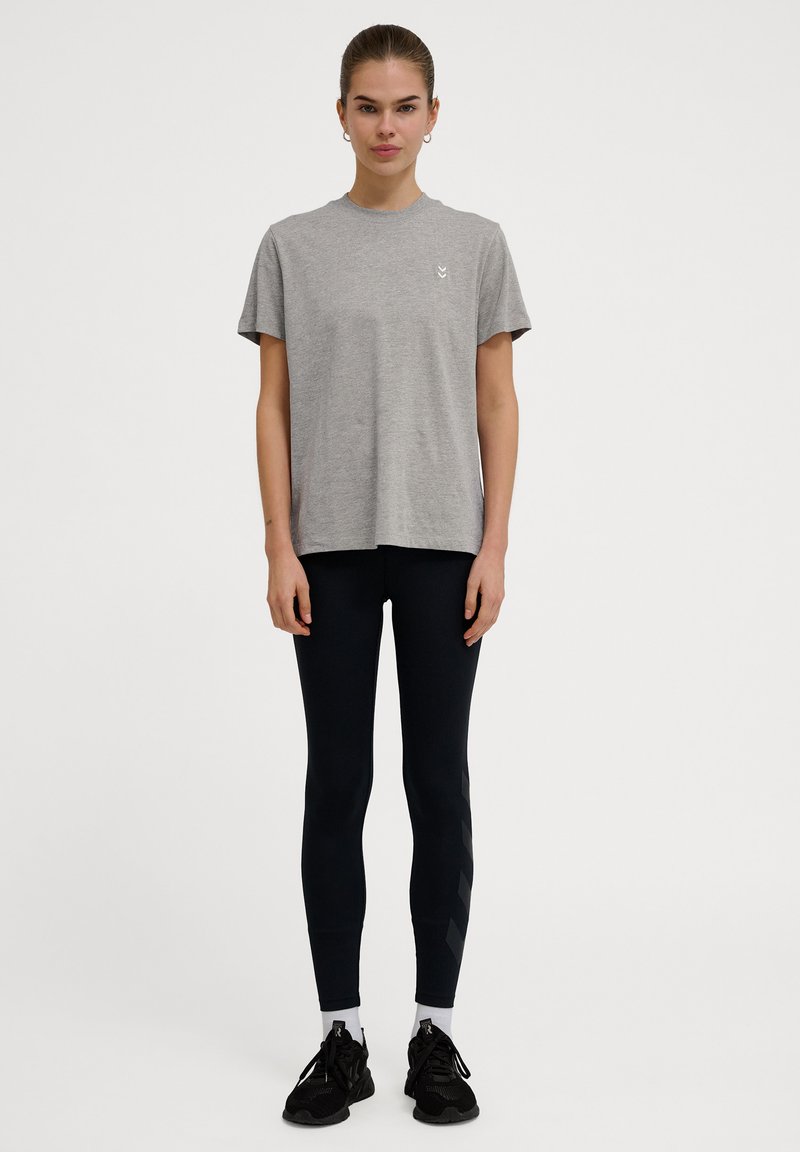 Herre grå bomulds t-shirt med korte ærmer, samlet med sorte leggings med sidelister og sorte træningssko med hvide detaljer.