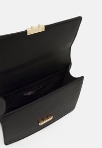 Borsa a tracolla in pelle nera con una texture liscia, chiusura in hardware dorato e una tasca interna. Design minimalista con linee pulite.