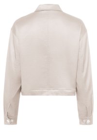 Kurz geschnittene Jacke aus hellbeigem Satin mit Kragen, langen Ärmeln und knöpfbaren Manschetten, die einen dezenten Glanz und eine glatte Textur aufweisen.