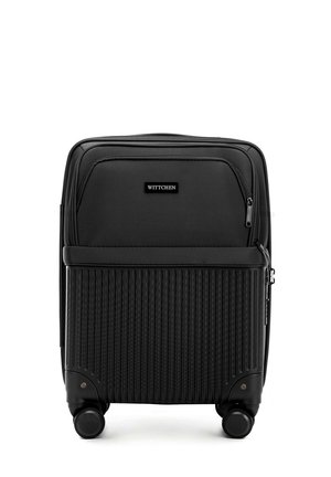 Black rolling suitcase with ribbed design on the lower half, zippered pockets on top, and four wheels for mobility. Marked “Wittchen.”