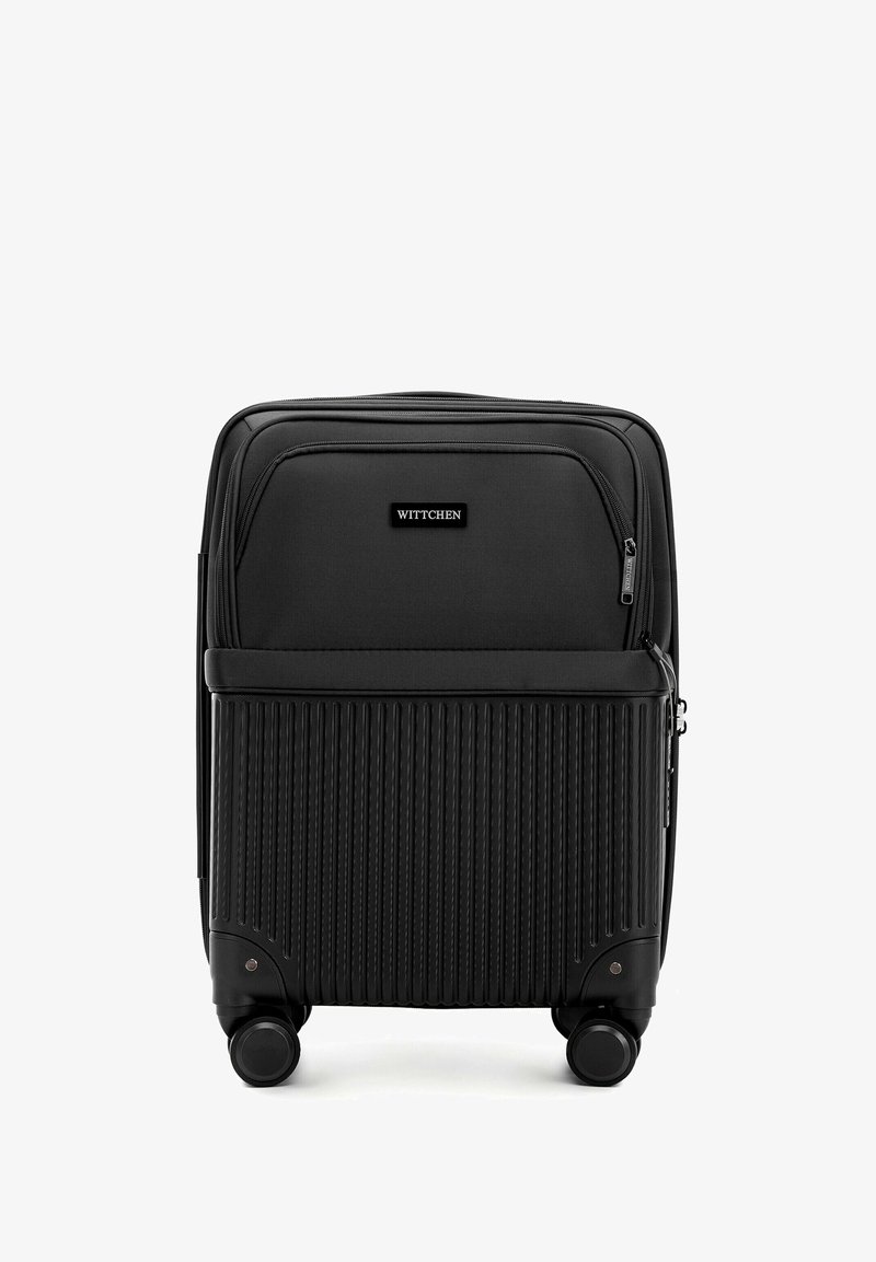 Maleta negra con diseño acanalado en la mitad inferior, bolsillos con cremallera en la parte superior y cuatro ruedas para movilidad. Marcada "Wittchen."