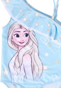 Costume da bagno azzurro chiaro con illustrazione di un personaggio, motivi a stelle e bordo superiore arricciato. Realizzato in tessuto elastico e morbido.