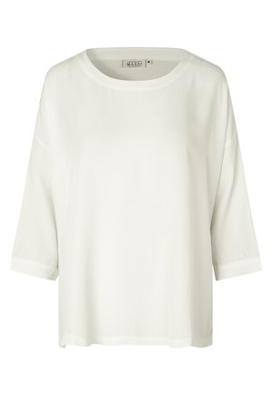 Haut blanc, ample, fabriqué en tissu léger. Il présente un col rond, des manches courtes et un ourlet droit. Design minimaliste.