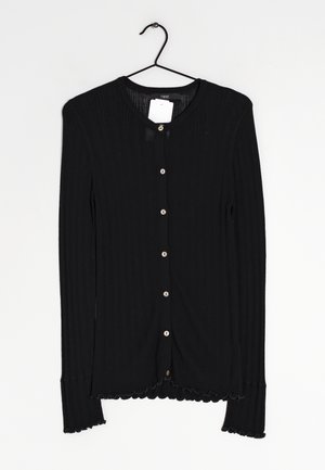Cardigan noir à côtes avec manches longues, col rond, fermeture à boutons et bords festonnés aux manches et à l'ourlet. Équipé de boutons en fausse perle.