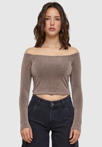Off-shoulder top met lange mouwen, metallic bronzen stof, getailleerd ontwerp, cropped lengte, gestructureerd oppervlak, gecombineerd met high-waisted donkere broek.