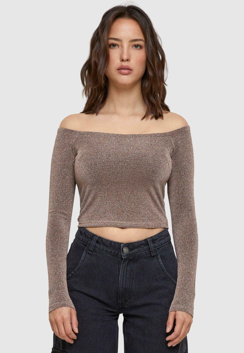 Off-shoulder top met lange mouwen, metallic bronzen stof, getailleerd ontwerp, cropped lengte, gestructureerd oppervlak, gecombineerd met high-waisted donkere broek.