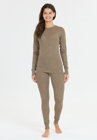 Brun långärmad termisk topp och figurnära leggings gjorda av mjukt material, med en subtil textur och ribbade detaljer vid ärmsluten.