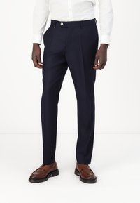 Tmavě modré kalhoty na míru vyrobené z hladkého materiálu, slim fit střihu, s jedním předním záhybem a jednoduchým zapínáním na knoflík.