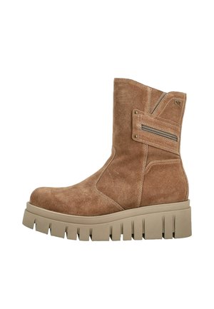 Botte mi-mollet en daim beige avec semelle crantée épaisse beige et détail zippé sur le côté.