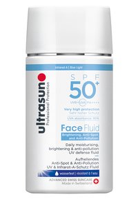 Flacon cylindrique blanc avec un bouchon en argent. Présente du texte bleu et rouge indiquant un SPF 50+, des avantages anti-pollution et des propriétés hydratantes.