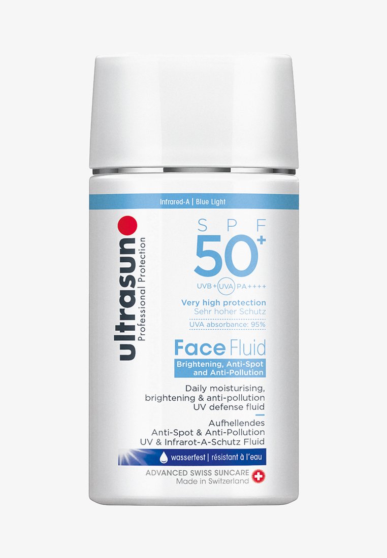 Hvit sylinderformet flaske med sølvhette. Har blå og rød tekst som indikerer SPF 50+, anti-forurensningsfordeler og fuktighetsgivende egenskaper.