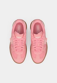 Rosa Sneakers aus Wildleder und Mesh-Materialien, mit runder Form, strukturierten Akzenten und einer Sohle aus Gummi. Die Schnürsenkel verlaufen zentral ineinander.