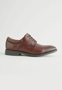 Chaussure de ville en cuir marron avec une finition lisse, un design à lacets, un bout arrondi et une semelle en caoutchouc noir à profil bas avec des détails de crans.