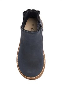 Botín azul de ante con interior forrado, borde superior con ondas, cremallera lateral y suela marrón claro con costuras blancas. Talla 25.