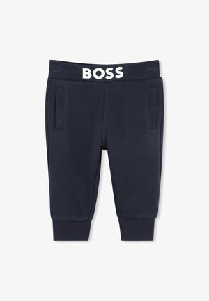 Pantalons de jogging bleu marine avec une texture côtelée, dotés de poches avant et d'une taille élastique blanche arborant le logo "BOSS" en évidence.