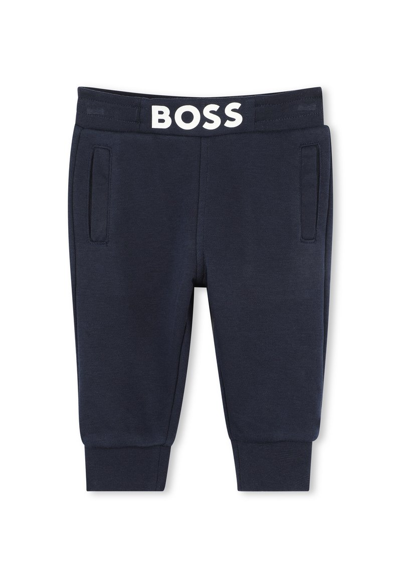 Pantaloni della tuta blu navy con texture a coste, dotati di tasche frontali e una vita elasticizzata bianca con il logo "BOSS" in evidenza.