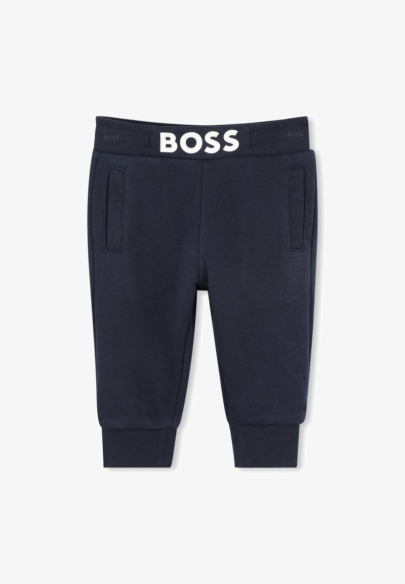Pantaloni della tuta blu navy con texture a coste, dotati di tasche frontali e una vita elasticizzata bianca con il logo "BOSS" in evidenza.