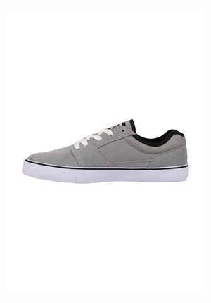 Grå lærredssneakers med hvide snørebånd, sorte detaljer og gummisål. Har en glat tekstur og minimal dekoration.