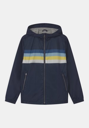 Námořnická větrovka se šedým vnitřkem, s horizontálními pruhy v modré, světle modré a žluté barvě přes hrudník a dvěma bočními kapsami.