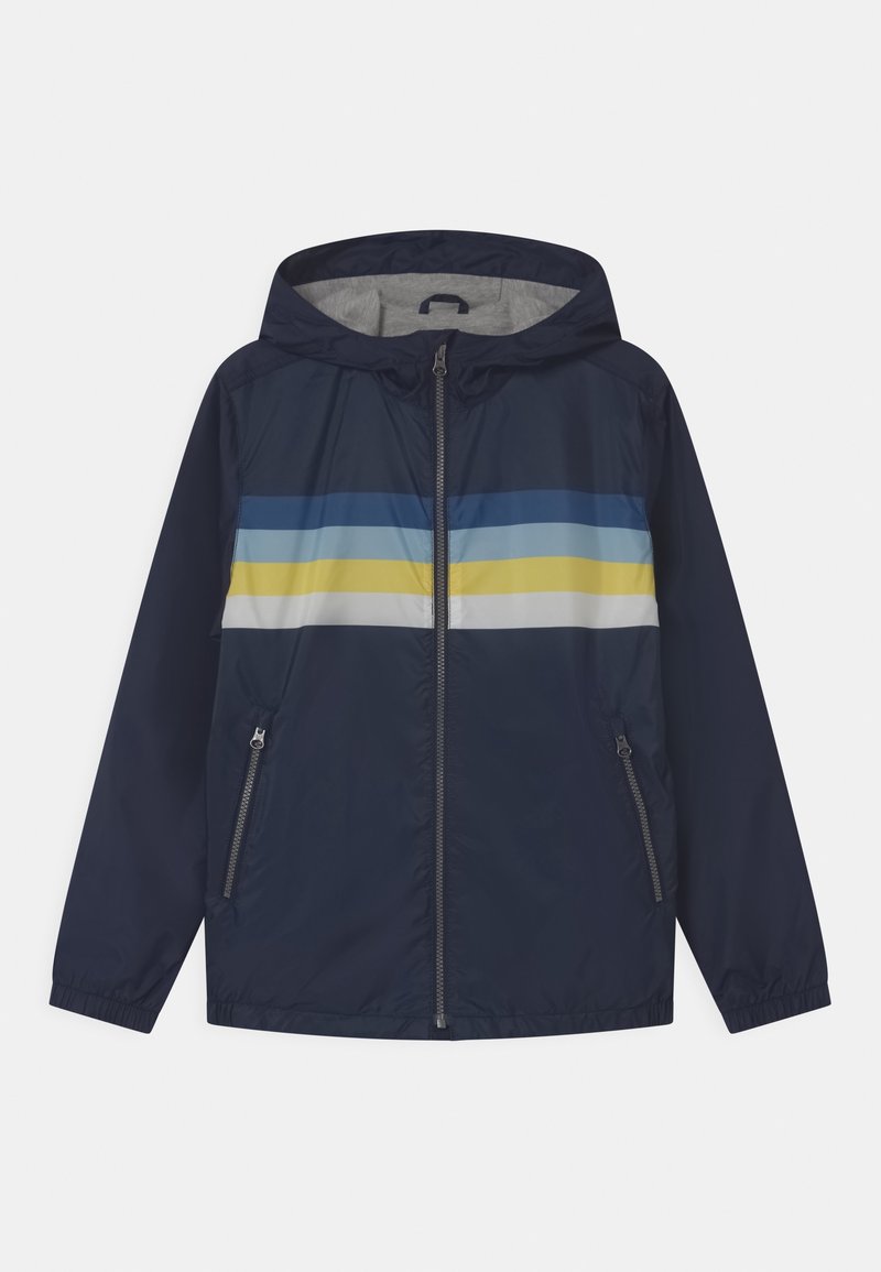 Granatowa kurtka wiatrówka z szarym wnętrzem, z poziomymi paskami w kolorach niebieskim, jasnoniebieskim i żółtym na wysokości klatki piersiowej oraz dwoma bocznymi kieszeniami.